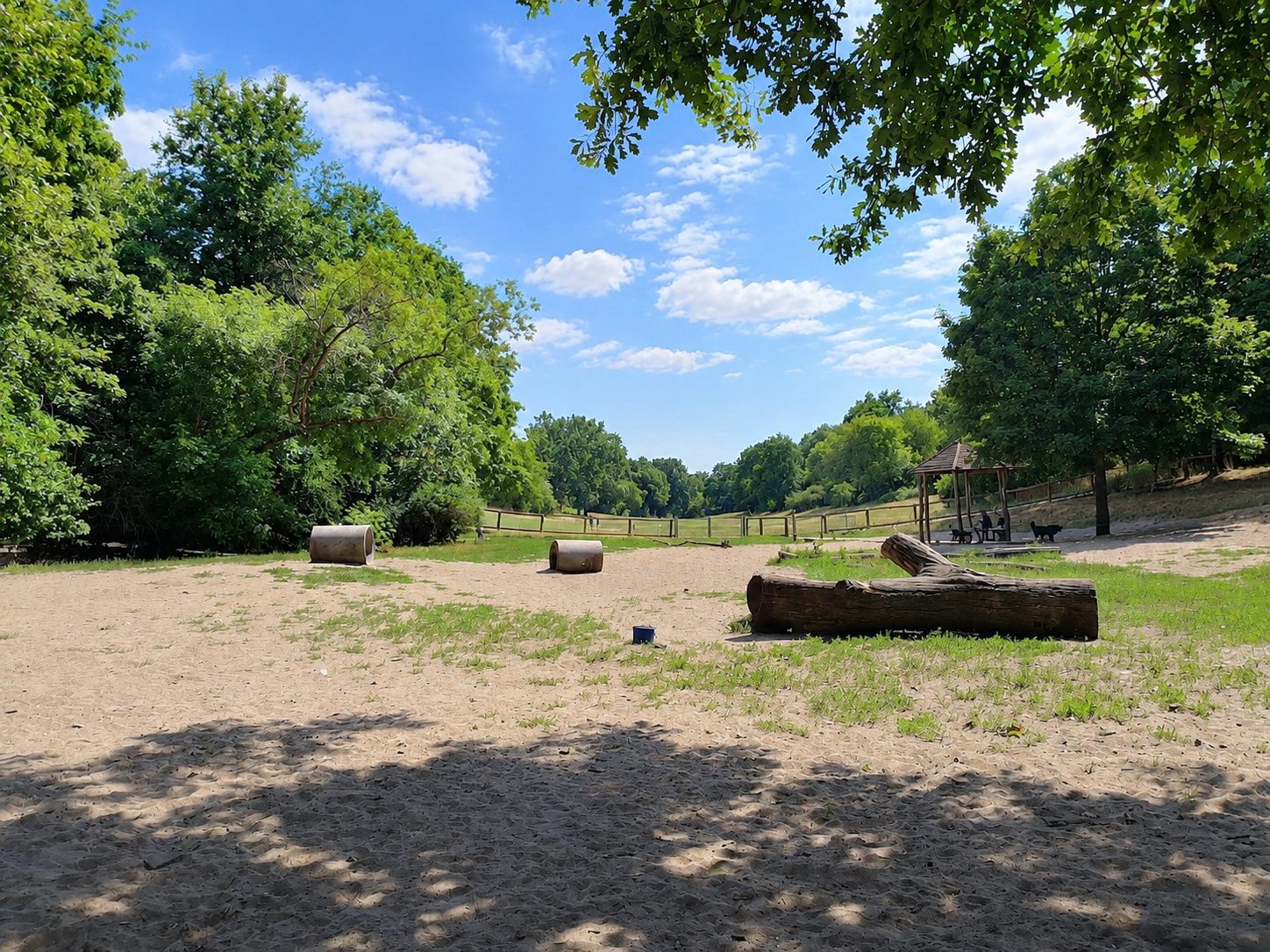 Sandfläche mit Tunneln, Baumstämmen und Bank im Sommer